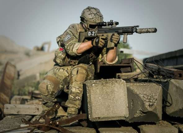 Soldier in camouflage holding a tactical rifle during defense training.
