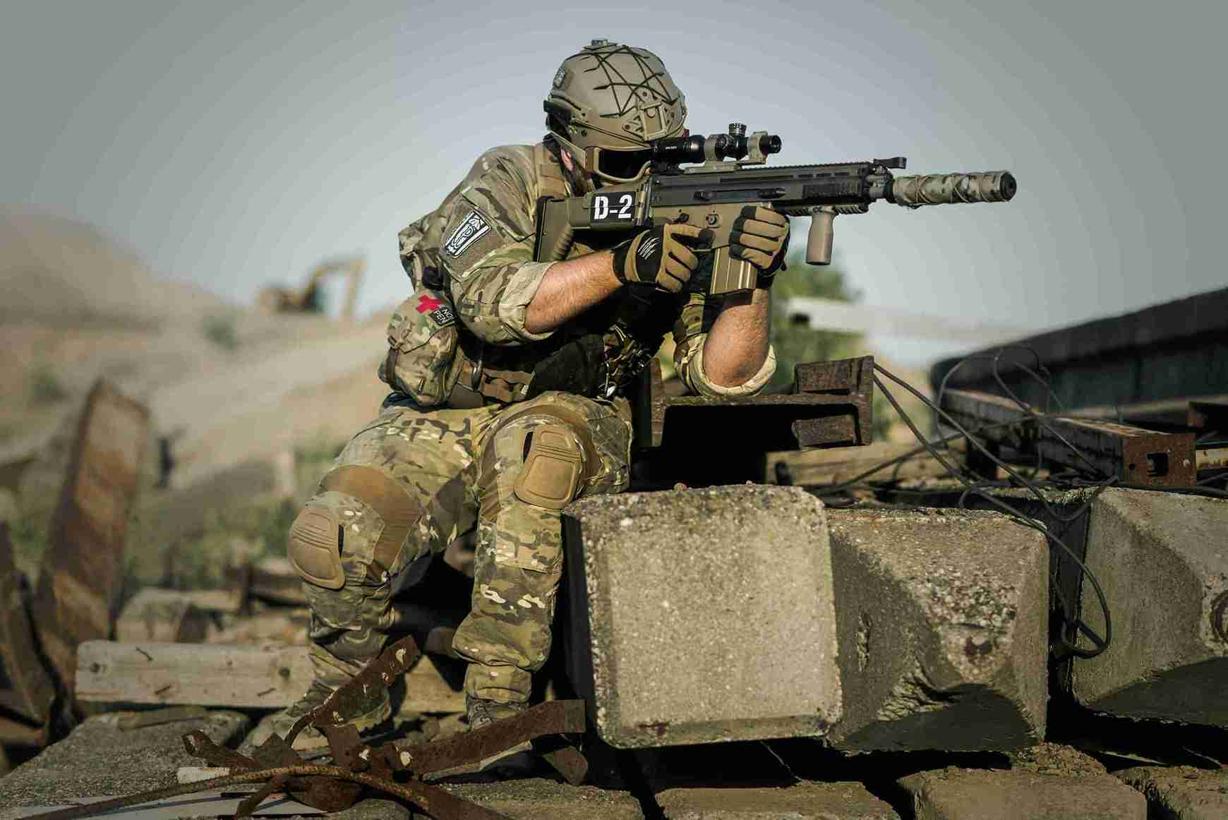 Soldier in camouflage holding a tactical rifle during defense training.