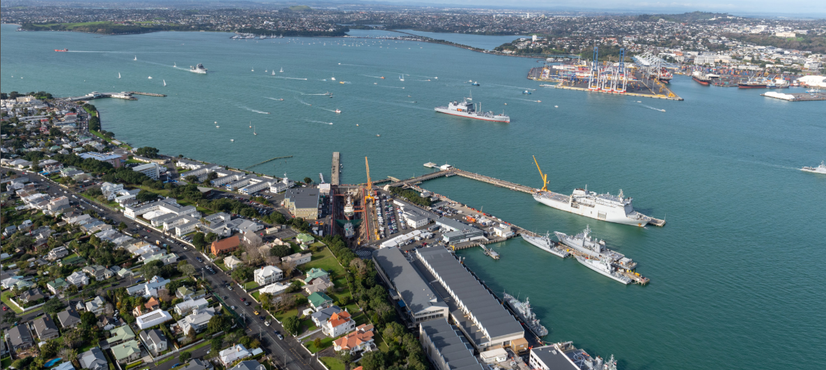 Aerial view of a coastal city and harbor with ships docked.