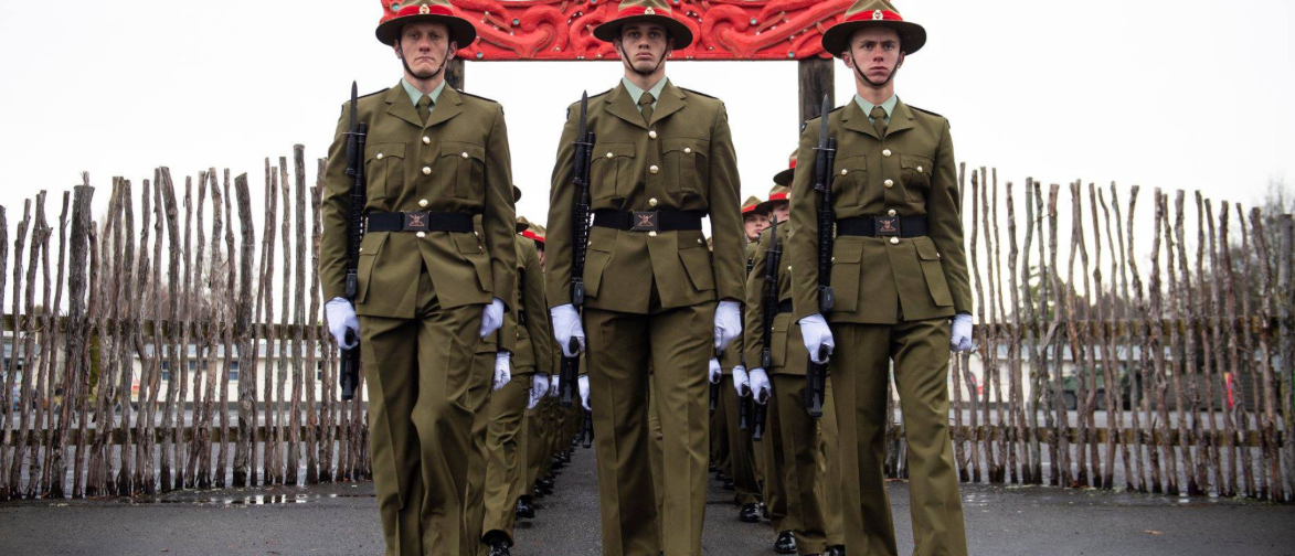 Soldiers in formal uniforms marching in formation.