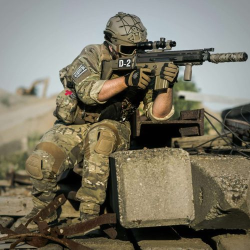 Soldier in camouflage holding a tactical rifle during defense training.