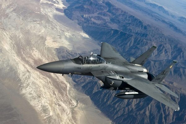 pexels-pixabay-76964 Fighter jet flying high above rugged mountains.